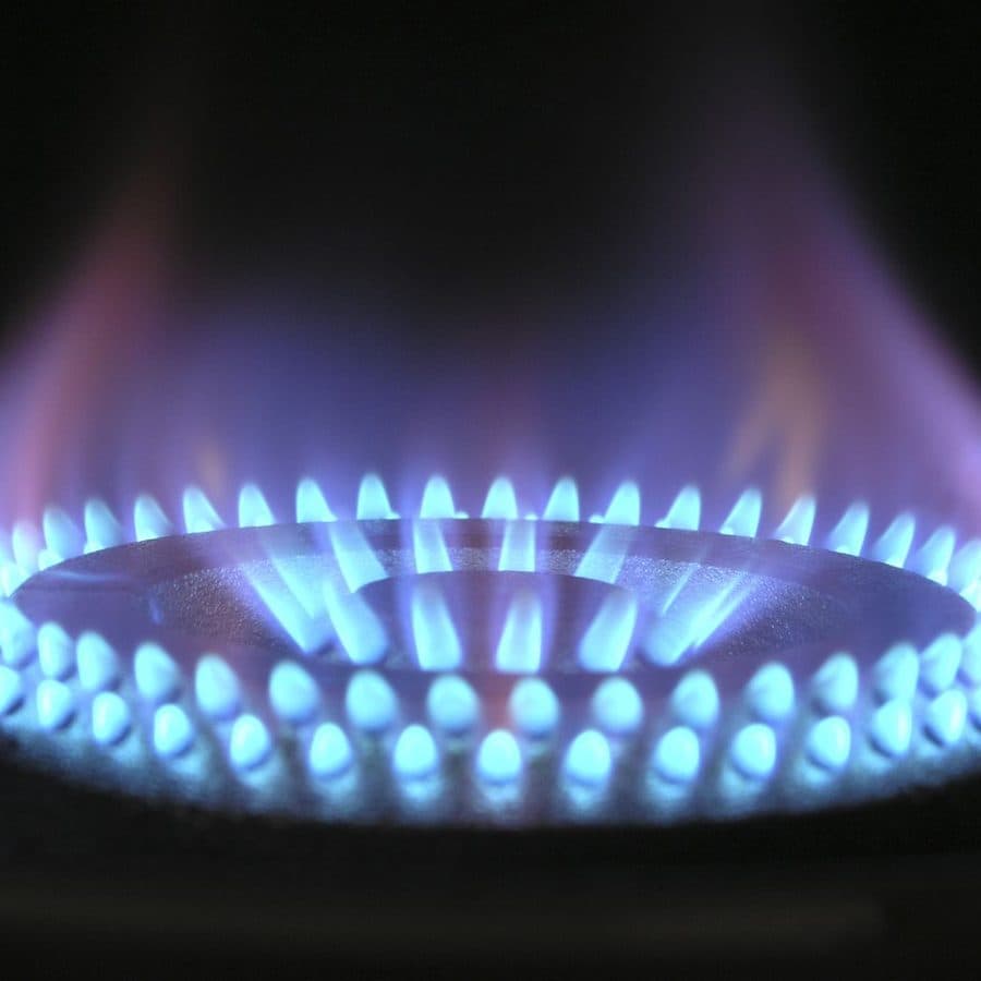 Quemador a gas encendido con la corona de llama azul pareja, señal de un quemador limpio